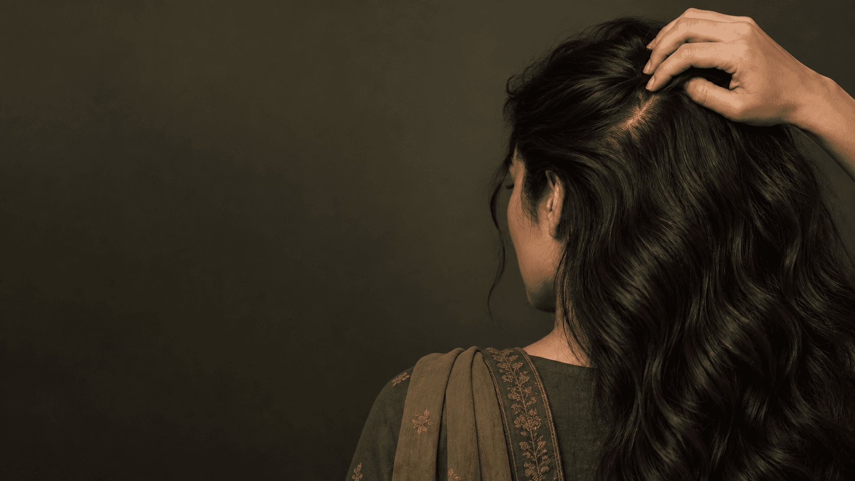 Pakistani woman checking the part line of her hair